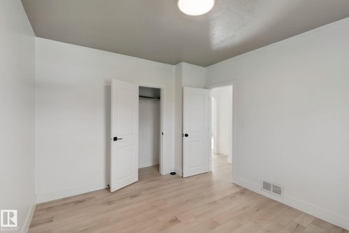 Light wood-finish flooring with white baseboards - 11914 124 Street Nw, Edmonton, AB 