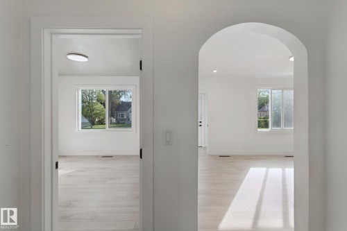 Archway entry into a bright space with wood-finish flooring and white walls - 11914 124 Street Nw, Edmonton, AB 