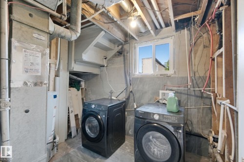 Basement utility area featuring a window, exposed ceiling joists, and a water heater - 11914 124 Street Nw, Edmonton, AB 