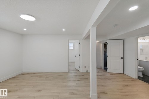 Light wood-finish flooring with white walls - 11914 124 Street Nw, Edmonton, AB 