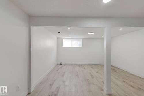 Recessed lighting, wood-finish flooring, white walls, and a window providing natural light - 11914 124 Street Nw, Edmonton, AB 