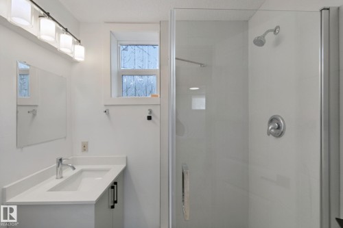 Contemporary vanity with integrated sink, chrome faucet, and quartz countertop - 11914 124 Street Nw, Edmonton, AB 