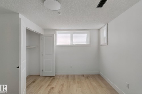 Wood-finish flooring, white walls, two windows with blinds, and an integrated ceiling light - 11914 124 Street Nw, Edmonton, AB 