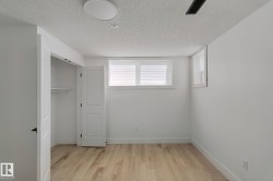 Wood-finish flooring, white walls, two windows with blinds, and an integrated ceiling light - 