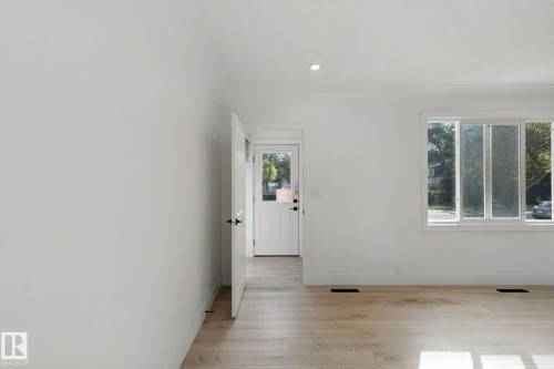 White walls, recessed ceiling lighting, wood-finish flooring, white trim, and a white paneled door with glass insert - 11914 124 Street Nw, Edmonton, AB 