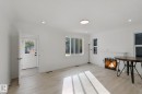 White walls, wood-finish flooring, multiple windows, recessed lighting, and a circular flush-mount ceiling light - 11914 124 Street Nw, Edmonton, AB 