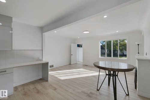 Recessed lighting, wood-finish flooring, built-in cabinetry with a white countertop, and a window with white trim - 11914 124 Street Nw, Edmonton, AB 