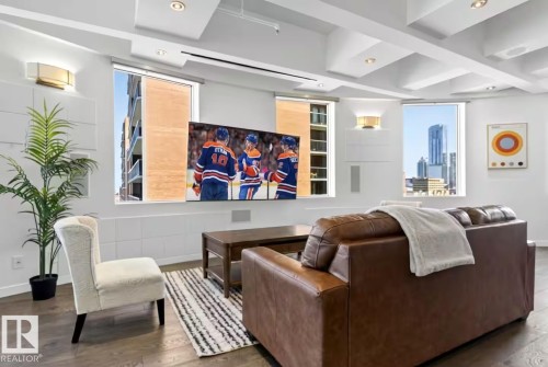 Coffered ceiling with recessed lighting, integrated wall speakers, wall-mounted sconces, and wood-finish flooring - #701 10105 109 St Nw, Edmonton, AB 