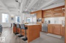 Gourmet kitchen with light wood cabinetry, a large center island, and stainless steel appliances - #701 10105 109 St Nw, Edmonton, AB 