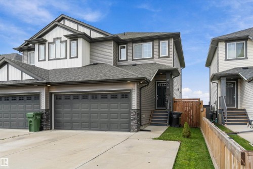 Modern facade featuring grey siding, white trim accents, and a dark asphalt shingle roof - 948 Morris Way, Leduc, AB 