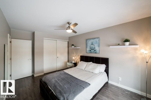 Wood-finish flooring, ceiling fan with integrated lighting, sliding closet doors, and wall-mounted shelving - 12228 134 Street Nw, Edmonton, AB 