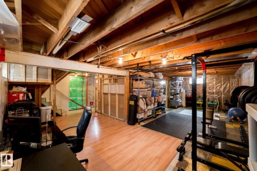 Lower level featuring exposed wood beam ceiling, wood-finish flooring, and framed partitioning - 12228 134 Street Nw, Edmonton, AB 
