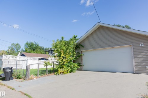 Siding exterior with a large garage door and concrete driveway - 12228 134 Street Nw, Edmonton, AB 