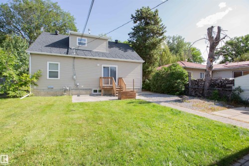 Expansive grassy yard with a concrete patio and gravel pathways - 12228 134 Street Nw, Edmonton, AB 