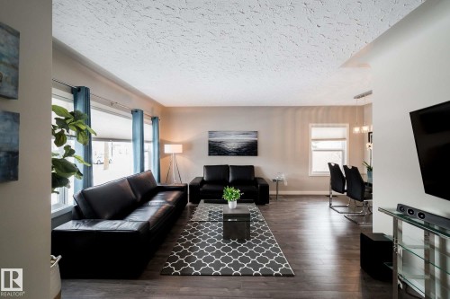 Wood-finish flooring throughout, multiple windows with roller shades, and a textured ceiling - 12228 134 Street Nw, Edmonton, AB 