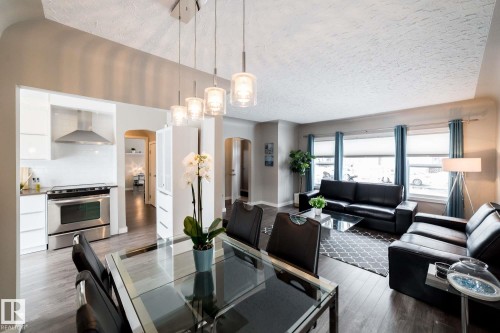 Open concept living and dining areas featuring dark wood-finish flooring - 12228 134 Street Nw, Edmonton, AB 