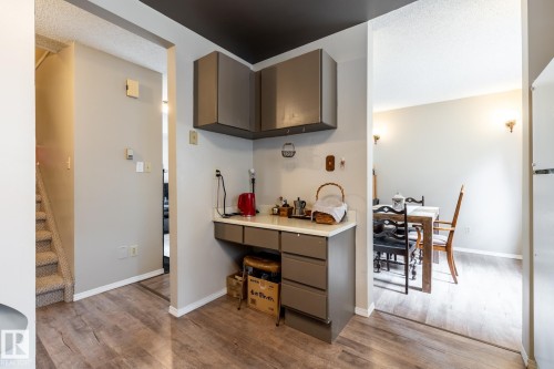 Built-in desk area featuring grey cabinetry and a light-colored countertop - #20 3812 20 Av Nw, Edmonton, AB 