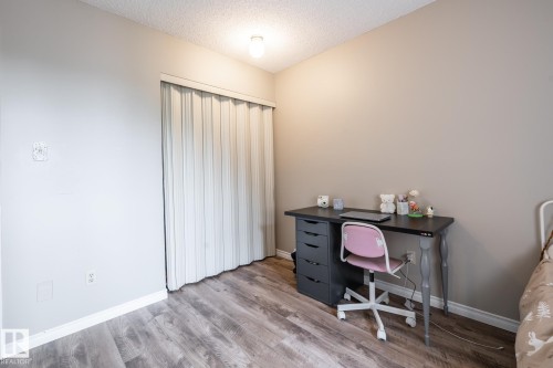 Room featuring wood-finish flooring, light-toned walls, and a white bi-fold closet door - #20 3812 20 Av Nw, Edmonton, AB 