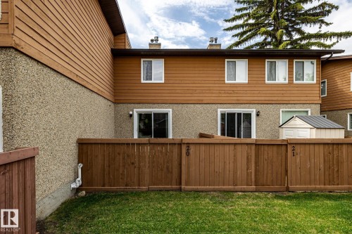Private fenced yard featuring a manicured lawn, a storage shed, and a privacy fence - #20 3812 20 Av Nw, Edmonton, AB 