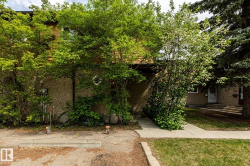 Multi-level exterior with textured stucco and wood-finish siding - #20 3812 20 Av Nw, Edmonton, AB 