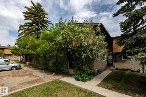 Multi-level exterior featuring wood paneling and stucco siding - #20 3812 20 Av Nw, Edmonton, AB 
