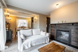 Living area featuring a dark wood-finish paneled fireplace with a black mantel - 