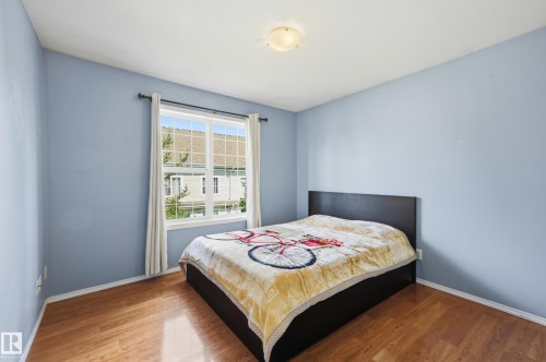 Wood-finish flooring with light blue wall paint - #85 150 Edwards Dr Sw, Edmonton, AB 
