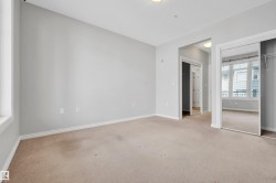 Recessed lighting, light-toned carpeting, and a mirrored closet door with built-in shelving - 