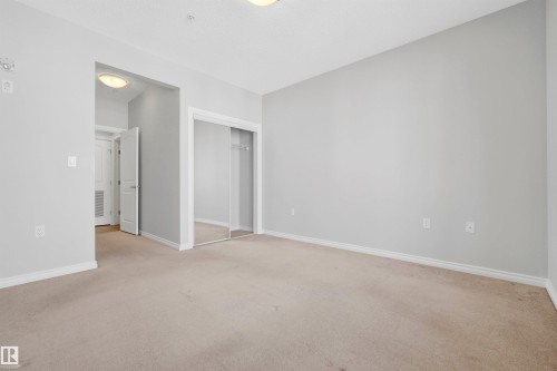 Carpeted flooring, mirrored sliding closet doors, and recessed lighting - #215 9820 165 St Nw, Edmonton, AB 