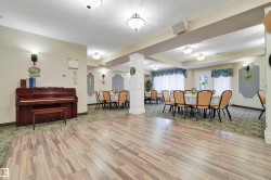 Expansive open space featuring diverse flooring, recessed lighting, decorative wall sconces, and architectural columns - 