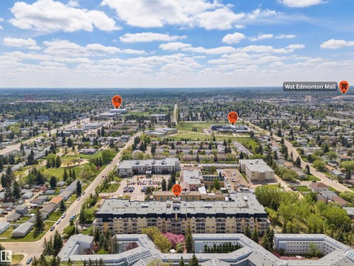 Aerial perspective of a developed urban area featuring multiple residential buildings and commercial structures - #215 9820 165 St Nw, Edmonton, AB 