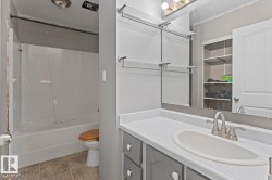 Bathroom vanity featuring a white countertop, oval sink, and brushed nickel faucet - 