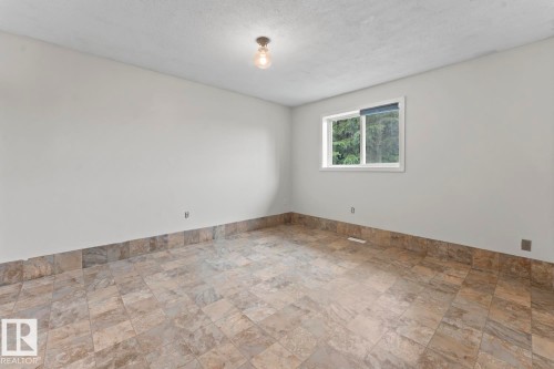 Room featuring neutral wall tones, square tile flooring, a single window, and a flush mount ceiling light - 4412 51 Avenue, Cold Lake, AB - Indoor Photo Showing Other Room