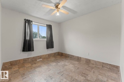 Interior space featuring light-toned walls, tile flooring, and a ceiling fan with integrated lighting - 4412 51 Avenue, Cold Lake, AB - Indoor Photo Showing Other Room