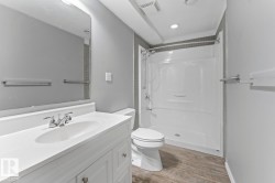 Bathroom featuring a white vanity with integrated sink, chrome faucet, and a large wall-mounted mirror - 