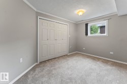 Carpeted room featuring a double bi-fold closet, a single window, overhead lighting, and crown molding - 