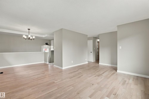 Light wood-finish flooring throughout, complemented by light gray wall tones and white trim - 9908 99 Street, Morinville, AB 