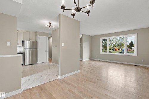 Neutral wall color, built-in shelving, carpet flooring, and a ceiling fan with integrated lighting - 9908 99 Street, Morinville, AB 