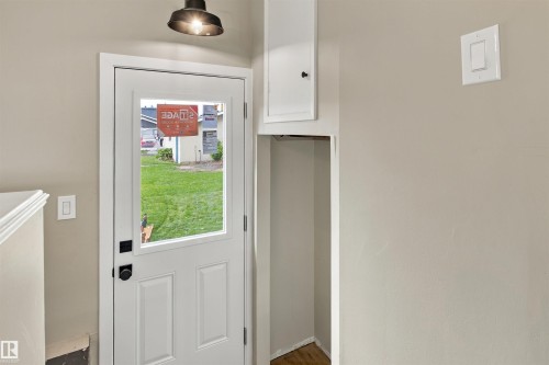 Expansive grassy yard featuring a built-in treehouse with a wooden railing and a detached structure with stucco siding - 9908 99 Street, Morinville, AB 