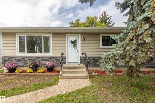 Light-toned horizontal siding with stone veneer accents - 9908 99 Street, Morinville, AB 