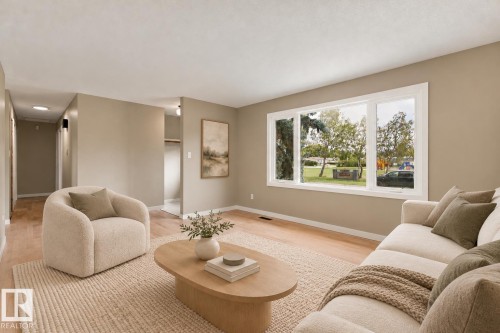 Spacious room with light wood-finish flooring, a large multi-pane window, and neutral wall paint - 9908 99 Street, Morinville, AB 