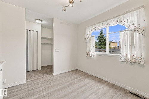 Light wood-finish flooring, bright overhead lighting, and built-in closet shelving - #3 18010 98 Av Nw, Edmonton, AB 