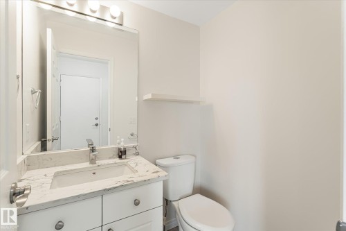 Vanity with white cabinetry, integrated sink, and stone countertop - #3 18010 98 Av Nw, Edmonton, AB 