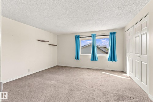 Soft carpet flooring, neutral wall tones, two integrated floating shelves, and bi-fold closet doors - #3 18010 98 Av Nw, Edmonton, AB 