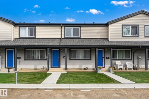 Two-story facade with light-colored horizontal siding, contrasting dark trim, and a dark shingle roof - #3 18010 98 Av Nw, Edmonton, AB 