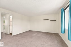 Carpeted room featuring white walls, a single window, and two floating wall shelves - 