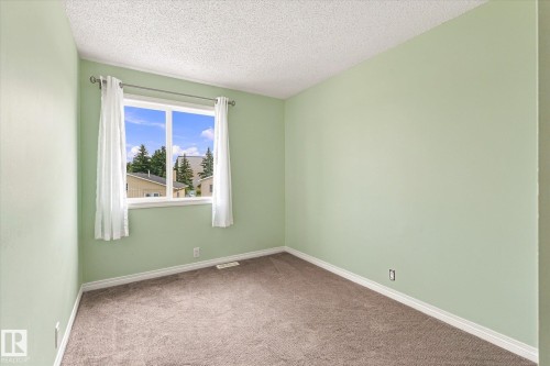 Recessed window with white trim, light green walls, and textured carpeting - #3 18010 98 Av Nw, Edmonton, AB 