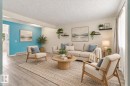 Expansive room with wood-finish flooring, accent wall, recessed lighting, and wall-mounted shelving - #3 18010 98 Av Nw, Edmonton, AB 