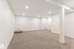 Recessed ceiling lighting, light-toned carpeting, white painted walls, white trim, and a white door - 