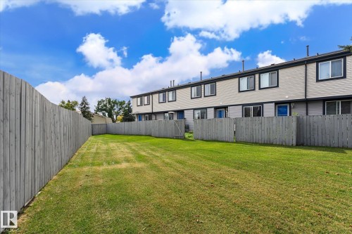 Expansive lawn area enclosed by a wood fence, offering private outdoor space - #3 18010 98 Av Nw, Edmonton, AB 